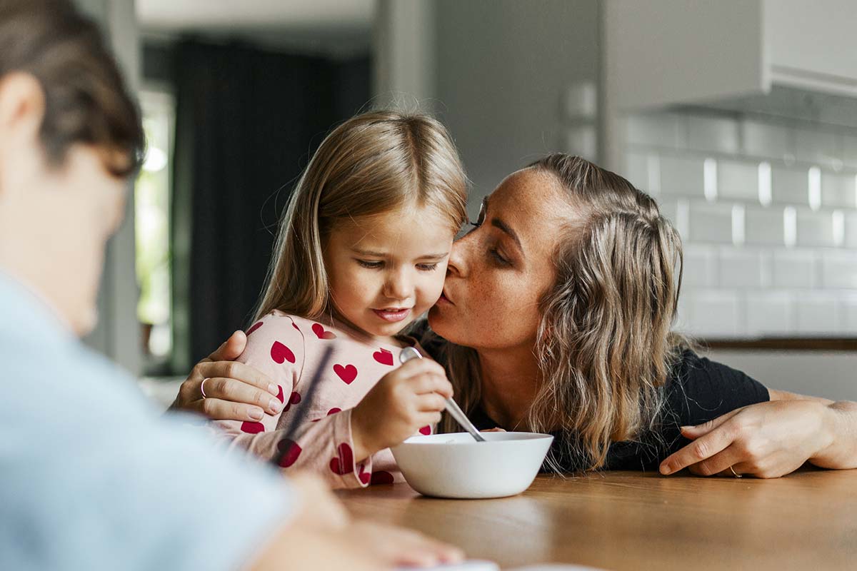 Mor og datter danser på kjøkkenet i bolig, til illustrasjon for tips til boliglån