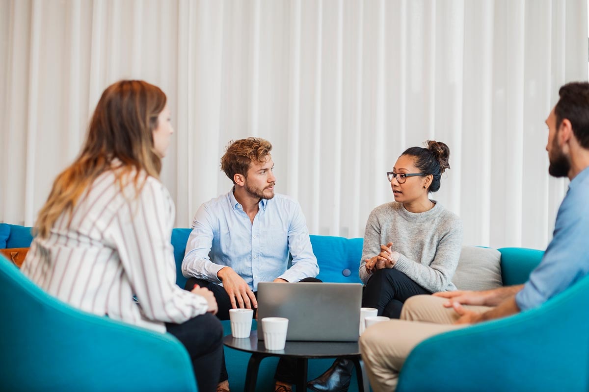Kollegaer som sitter i sofaen og prater, illustrasjon til åpenhetsloven