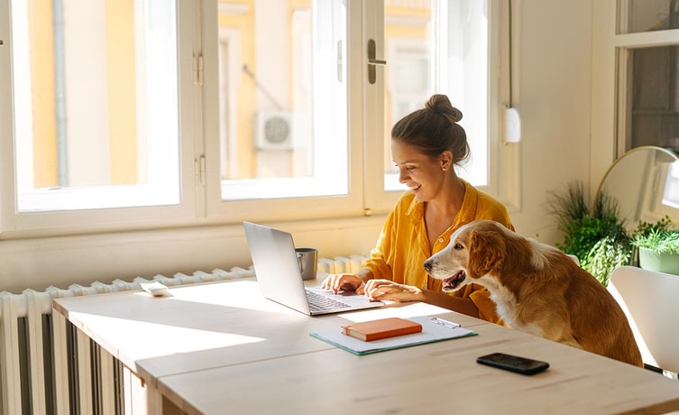 Dame og hund sitter ved spisebordet, til illustrasjon for hva er innskuddsrente