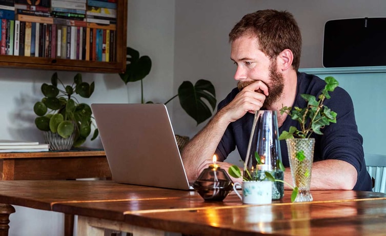 Mann ser tenkende på laptop - illustrasjon for pensjon
