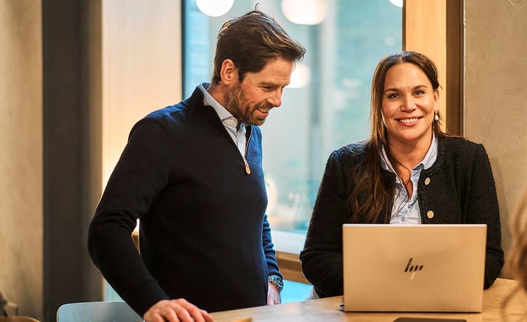 Ansatte i banken ser på laptop