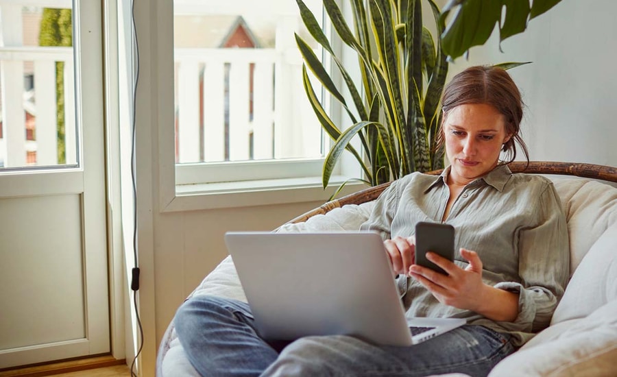 Dame med PC og mobil, til illustrasjon for Click to Pay