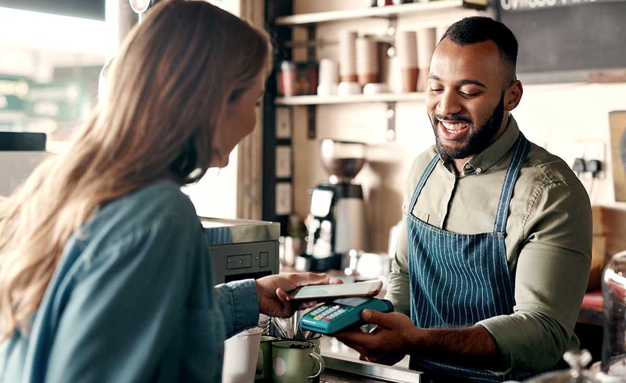 Kvinne betaler en barista for kaffe med Samsung Pay