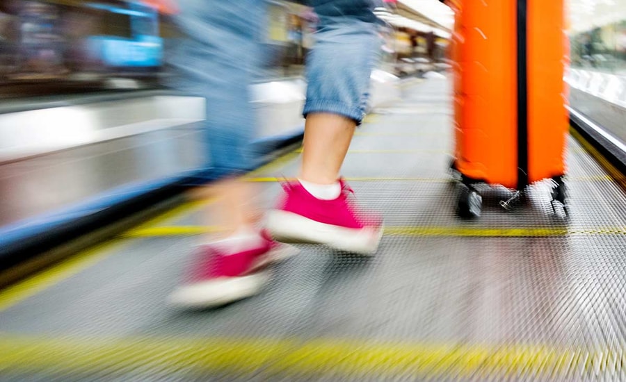 Dame i rulletrapp med koffert, til illustrasjon for trygt med to kort