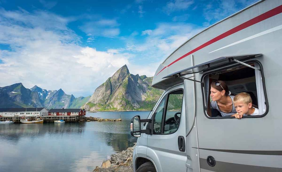 Dame og gutt i en caravan i lofoten med fjell i bakgrunnen, til illustrasjon caravanlån