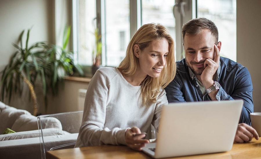 Par ser på laptop, til illustrasjon for refinansiere boliglånet