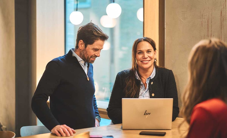 Ansatte i BN Bank sammen rund en pc, illustrasjon til boligsparing