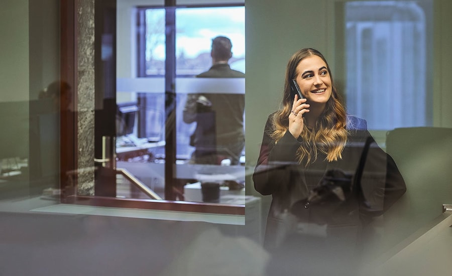 Kvinne som snakker i telefonen, mens hun vurderer fordele ved å ha en høyrentekonto