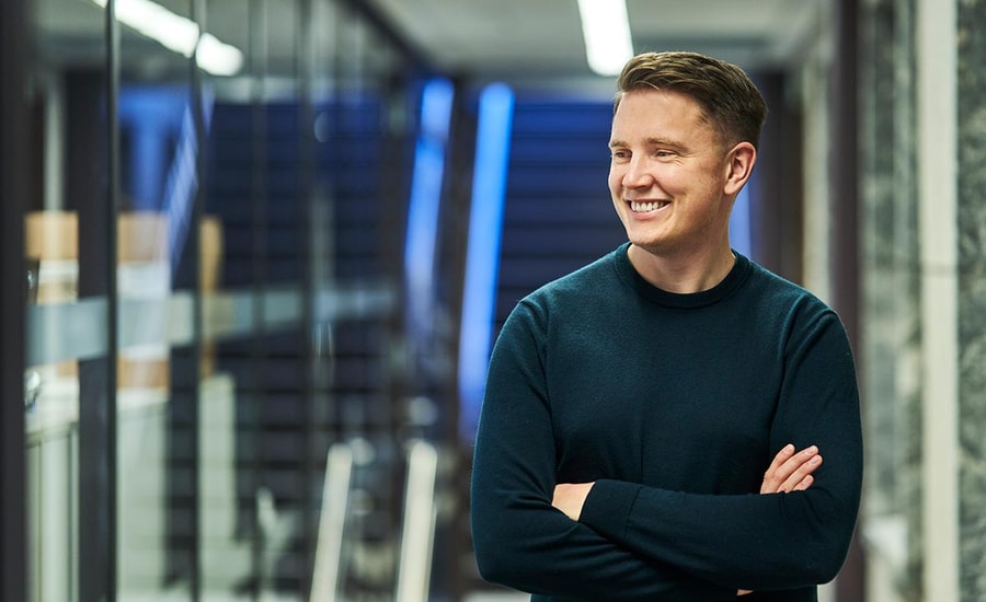 Ung mann i kontorlokale, til illustrasjon for bli kunde