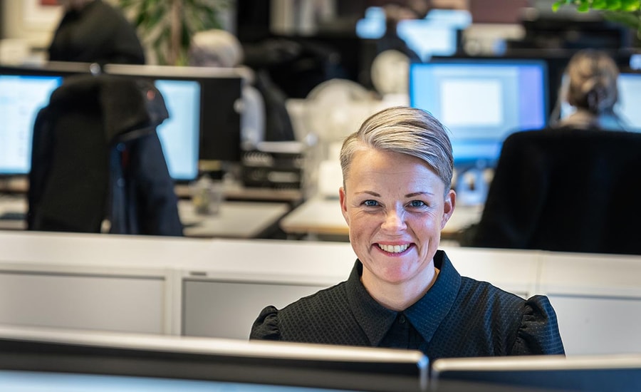 Rådgiver i BN Bank sitter i kontorlokalet bak PC-skjerm, til illustrasjon for boliglånsrente