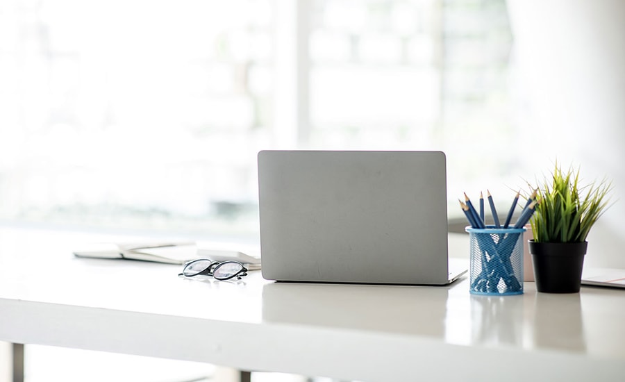 Bok, laptop, briller og blyanter på en skrivepult, til illustrasjon for problemer med innlogging