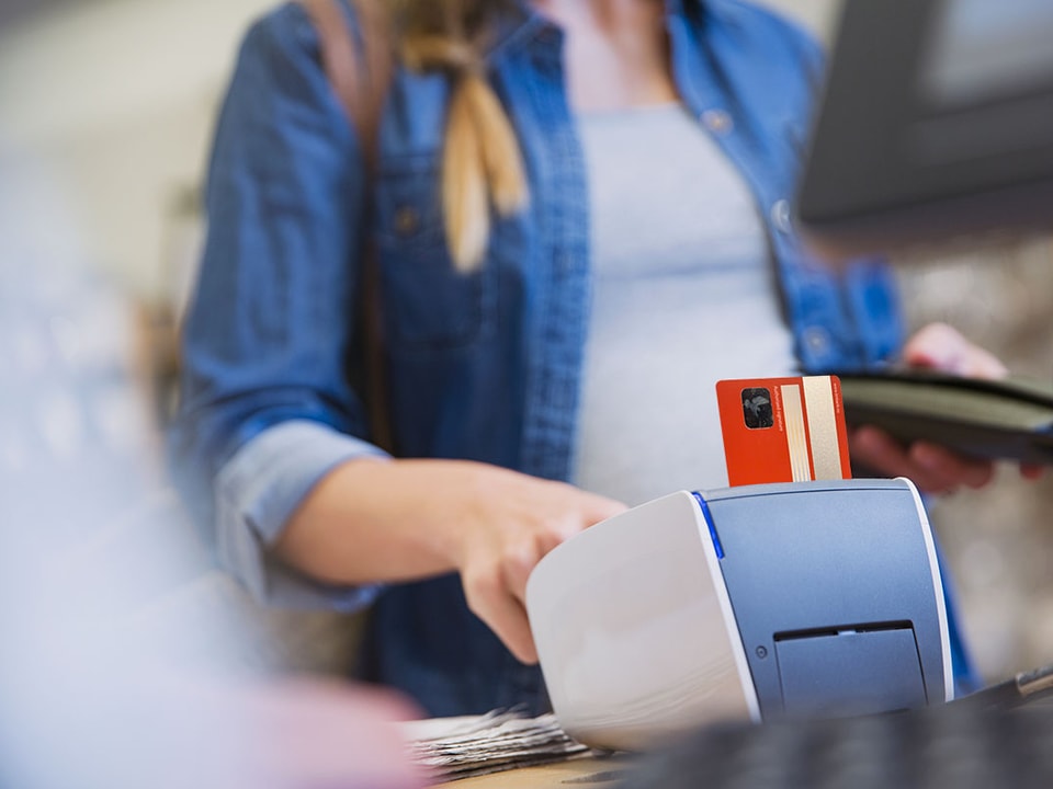 Dame betaler med kort i betalingsterminal - illustrasjon for betalingsterminal