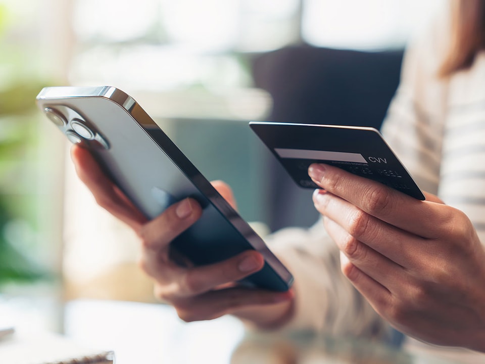 Dame holde kredittkort og mobil i hånden