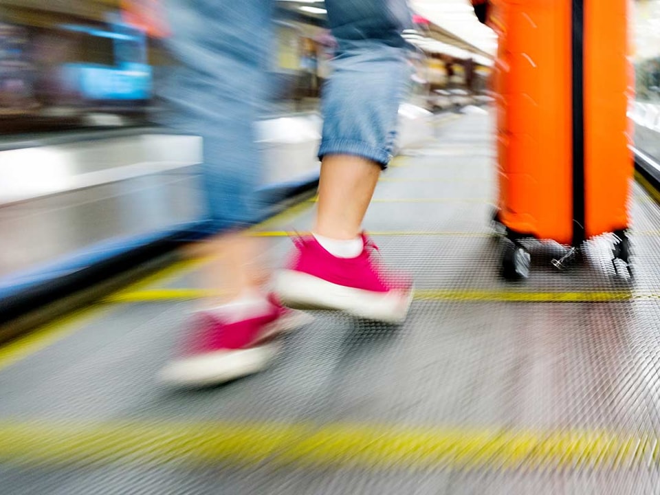 Dame i rulletrapp med koffert, til illustrasjon for trygt med to kort