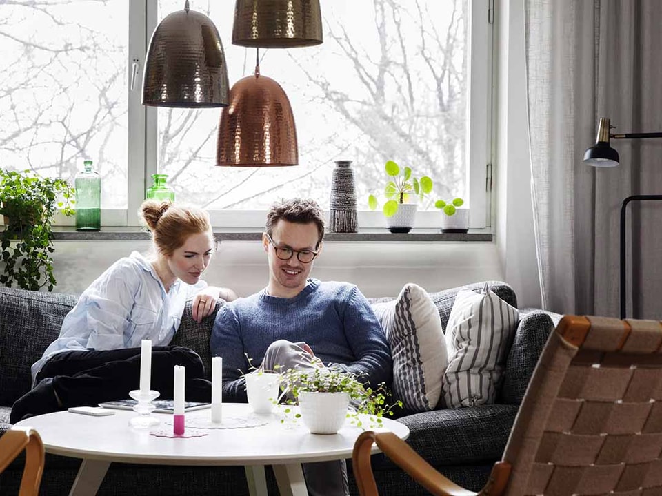 Par sitter sammen i koselig stue - illustrasjon for samboerkontrakt