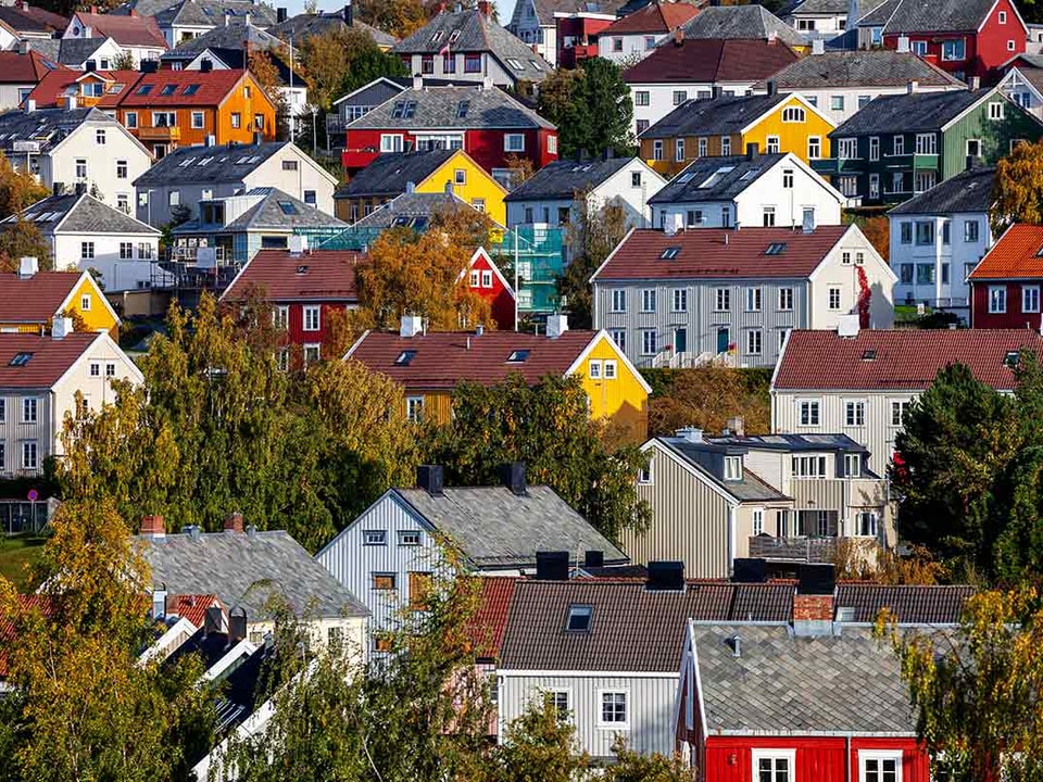 Kvinne sitter på kjøkkenbordet og forbereder seg til å kjøpe bolig