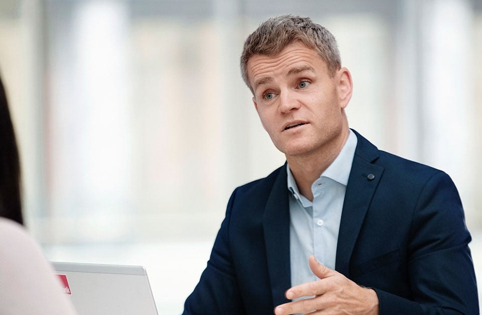 Anders jobber som boliglånsrådgiver i BN Bank og snakker med kunde, til illustrasjon for eiendomsmegler Krogsveen