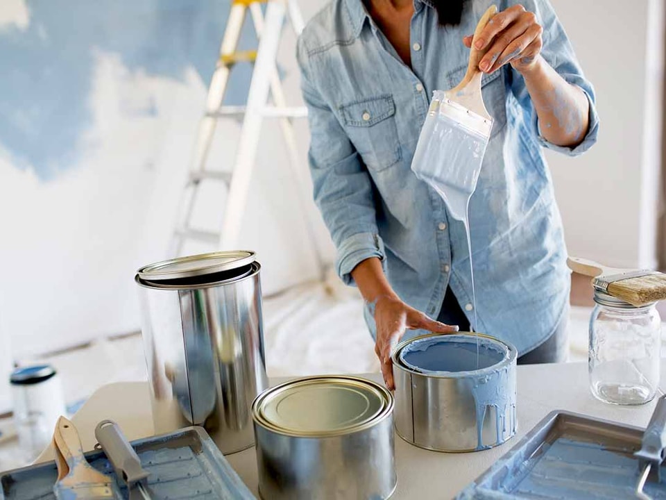 Dame med malingsspann og pensel, illustrasjon til pusse opp før salg av bolig