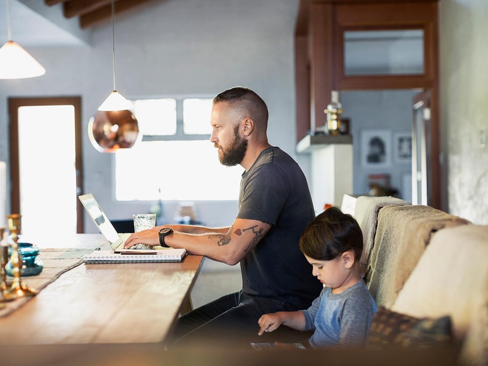 Far med sønn jobber på laptop, til illustrasjon for søknadspliktige tiltak