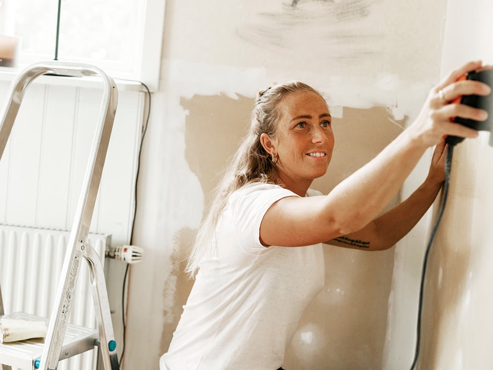 Dame sliper veggen, til illustrasjon for hvor mye koster det å pusse opp leilighet