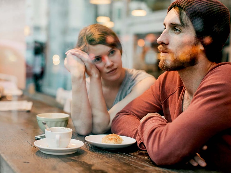 Kvinne og mann sitter på kafé, til illustrasjon for gjeld og parforhold