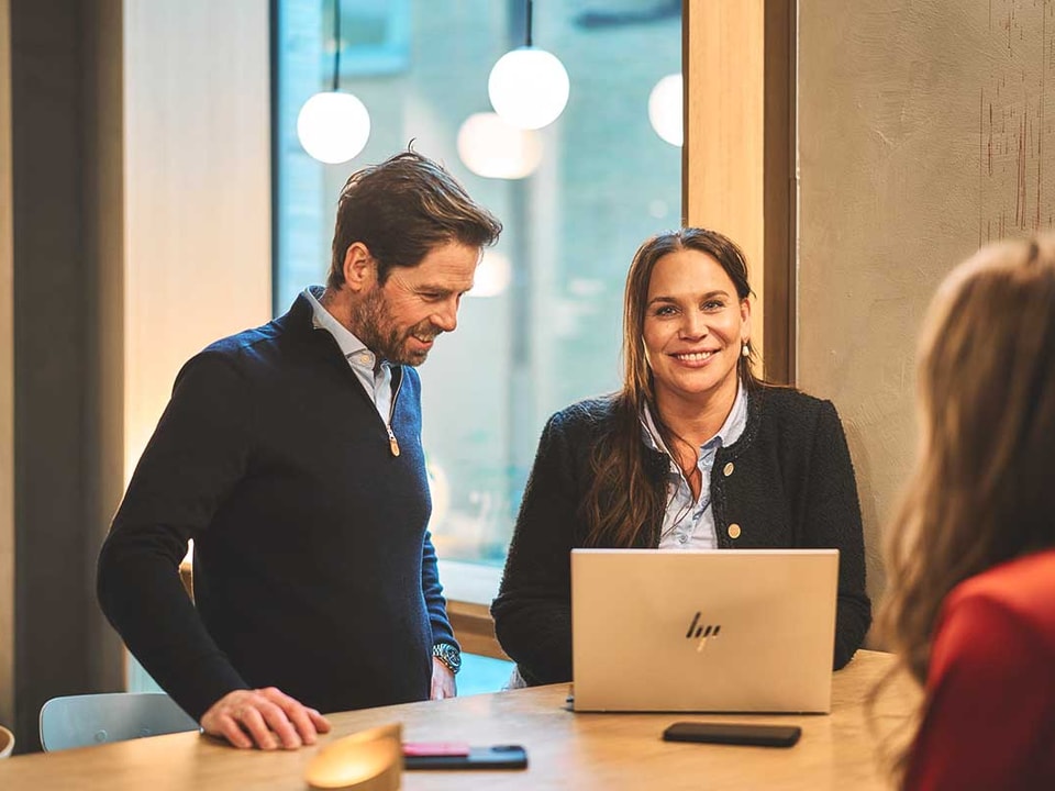 Ansatte i BN Bank sammen rund en pc, illustrasjon til boligsparing