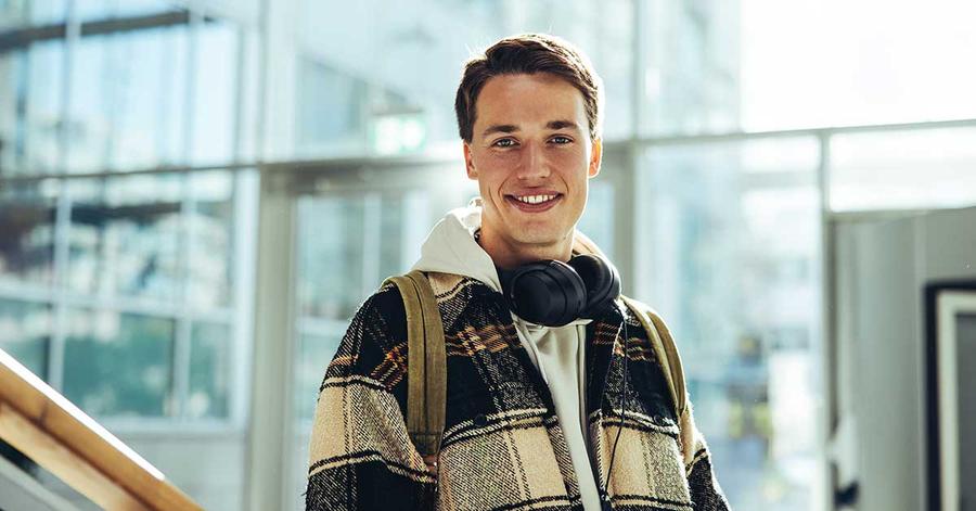 Ung gutt med headset rundt halsen smiler, til illustrasjon for å fylle opp BSU