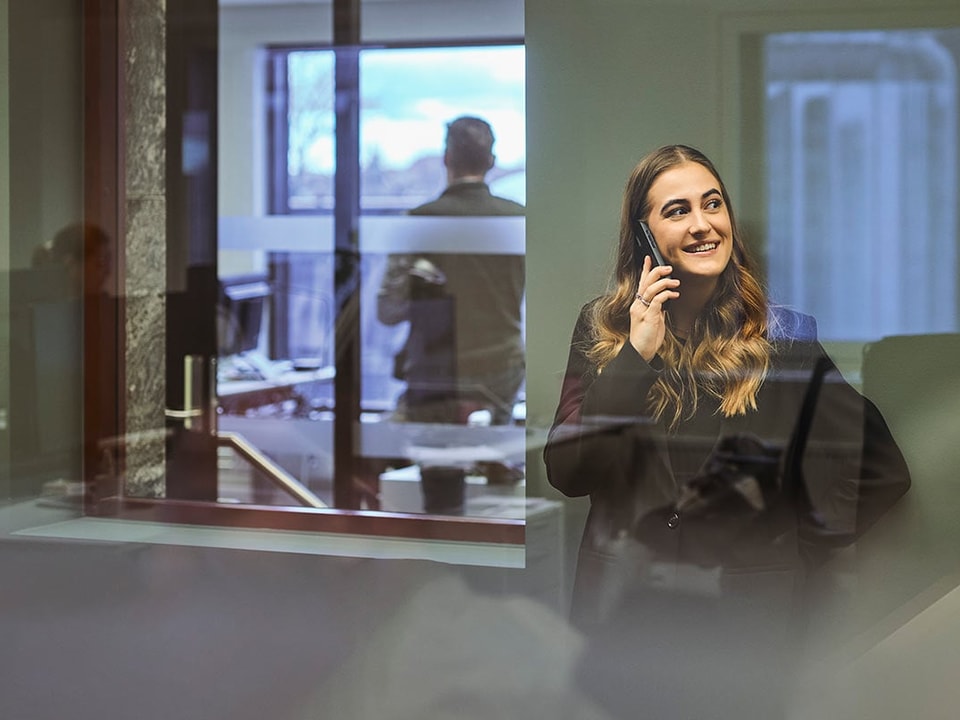 Kvinne som snakker i telefonen, mens hun vurderer fordele ved å ha en høyrentekonto