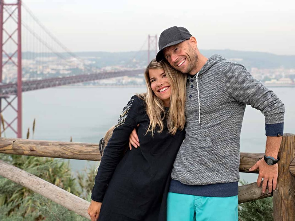 Kvinne og mann gir hverandre en klem på ferie fremfor Golden Bridge, til illustrasjon for sparekonto