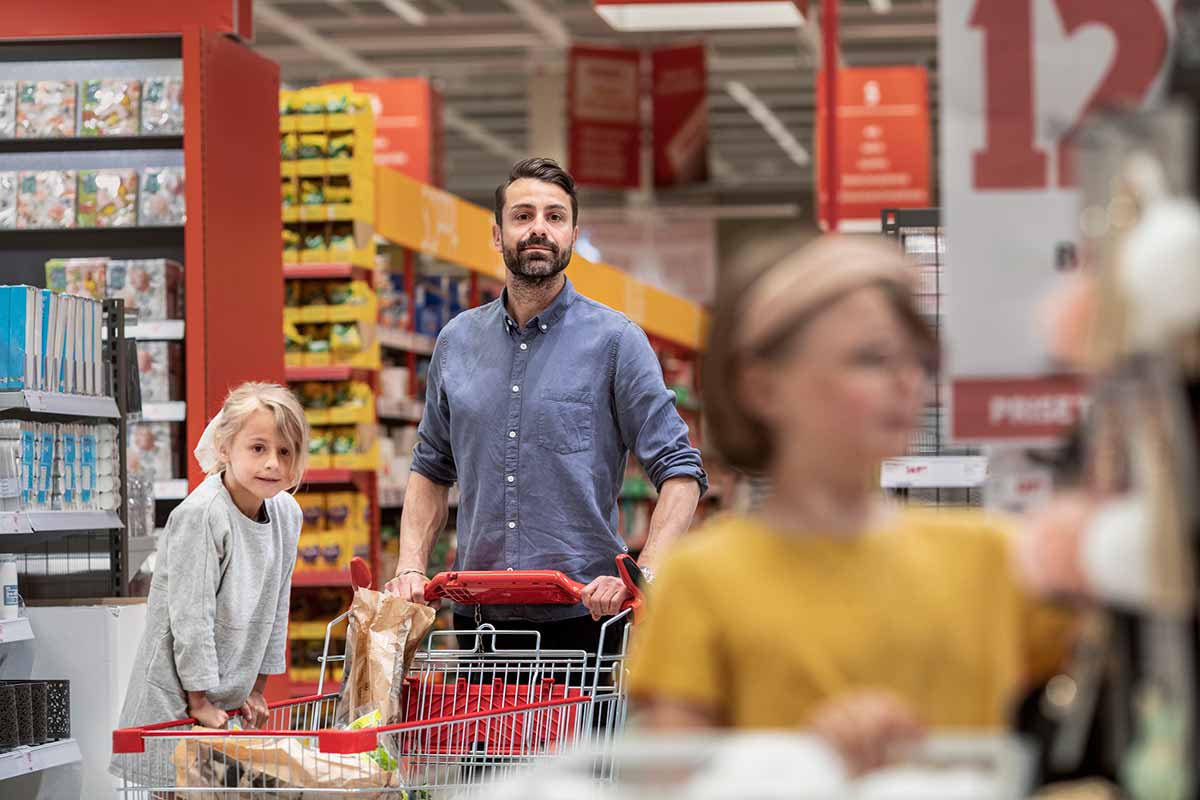 Far på handletur i matbutikken med datter, til illustrasjon for 50-30-20 regelen