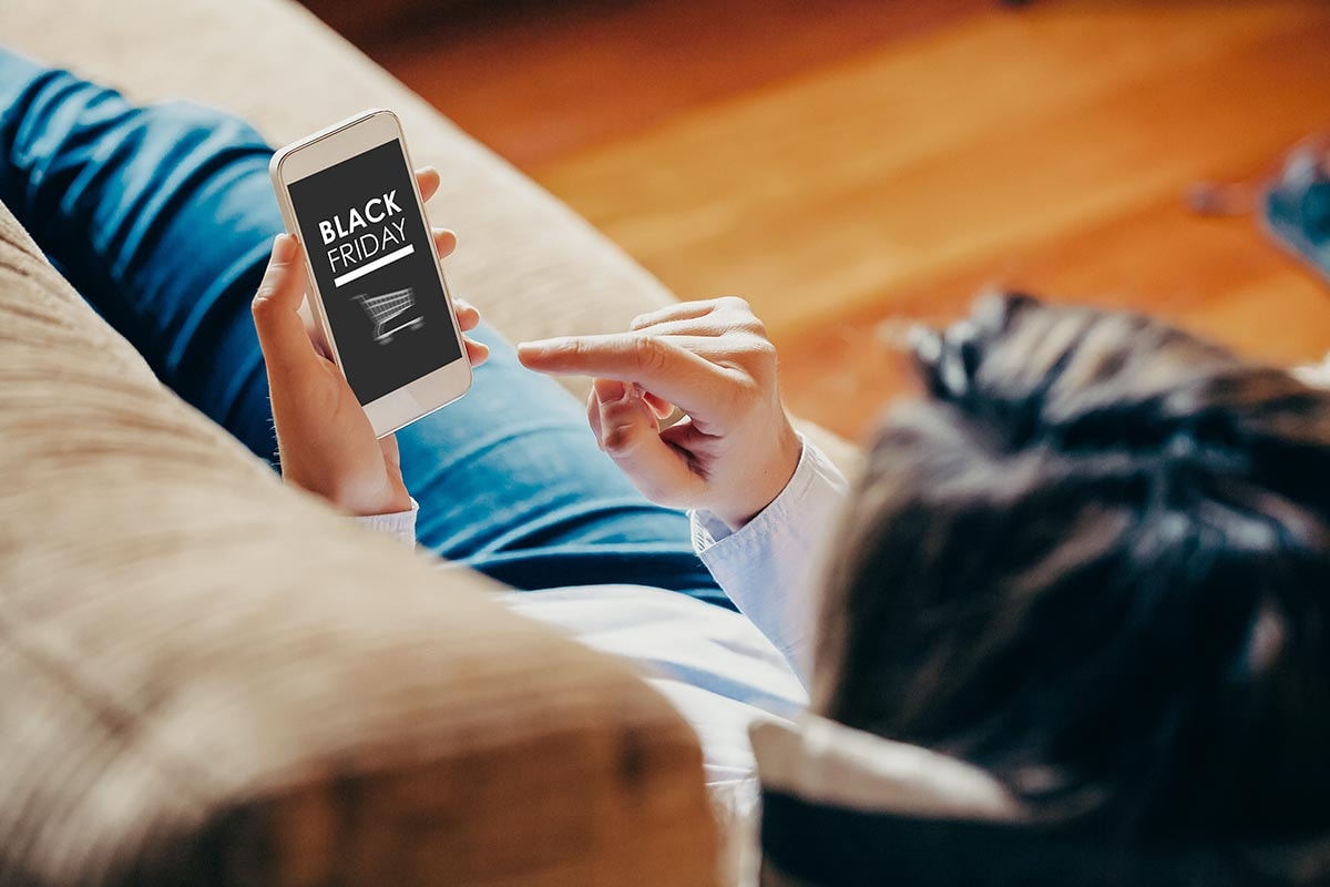 Kvinne mobil med Black Friday tilbud på skjerm, til illustrasjon for Black Friday