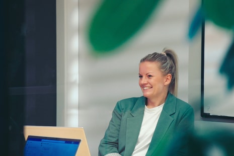 En kvinne sitter ved et skrivebord med laptop og planlegger sitt neste steg i prosessen med å bytte bank