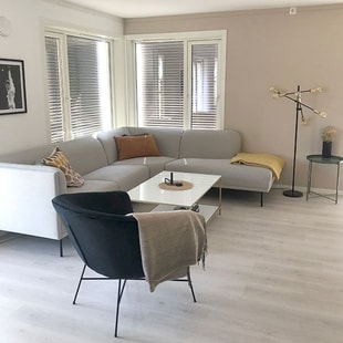 Moderne stue i leilighet med sofa, sofabord og stol, til illustrasjon for drømmen om egen bolig