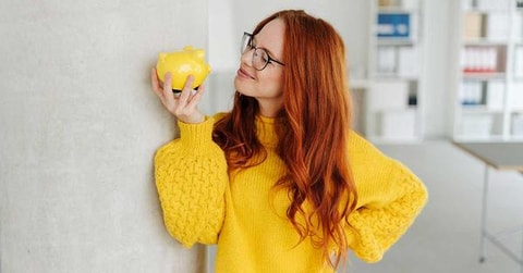 Dame holder en sparegris og sparer smart