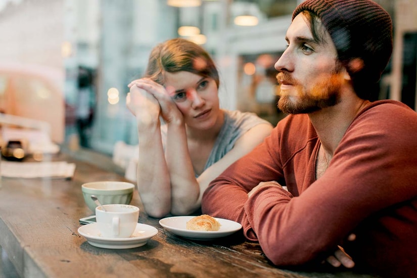 Kvinne og mann sitter på kafé, til illustrasjon for gjeld og parforhold