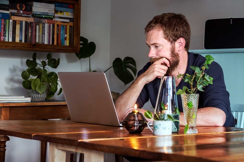 Mann ser tenkende på laptop - illustrasjon for pensjon