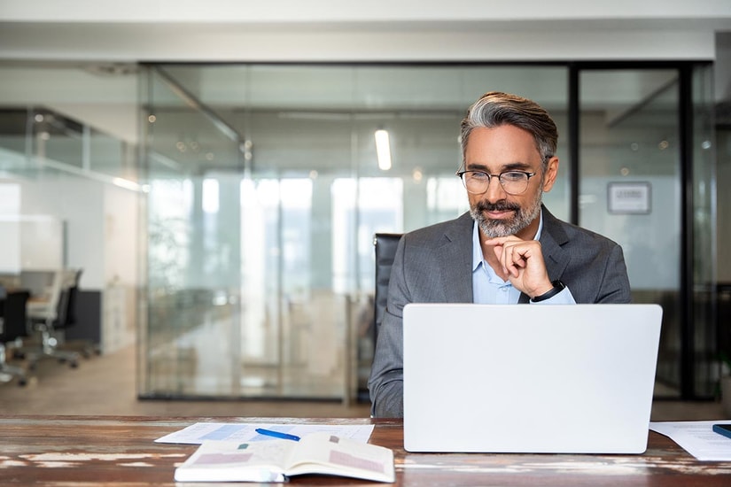 Mann sitter med laptop på kontoret