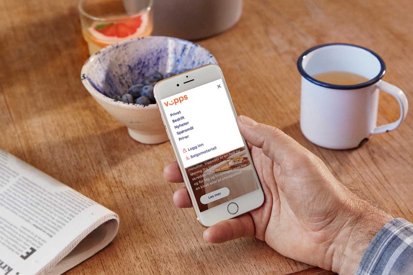 Mann holder en mobil som viser Vipps bedrift