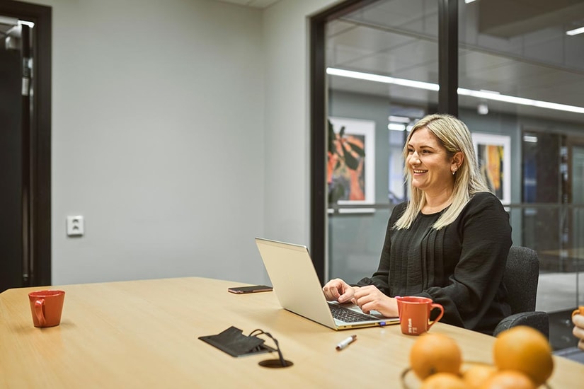 Bedriftsrådgiver Ailin sitter på møterom i BN Bank, til illustrasjon for bedriftskonto
