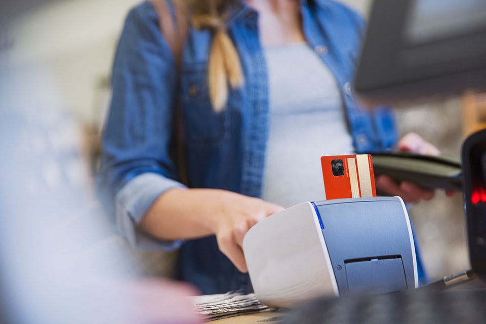 Dame betaler med kort i betalingsterminal - illustrasjon for betalingsterminal