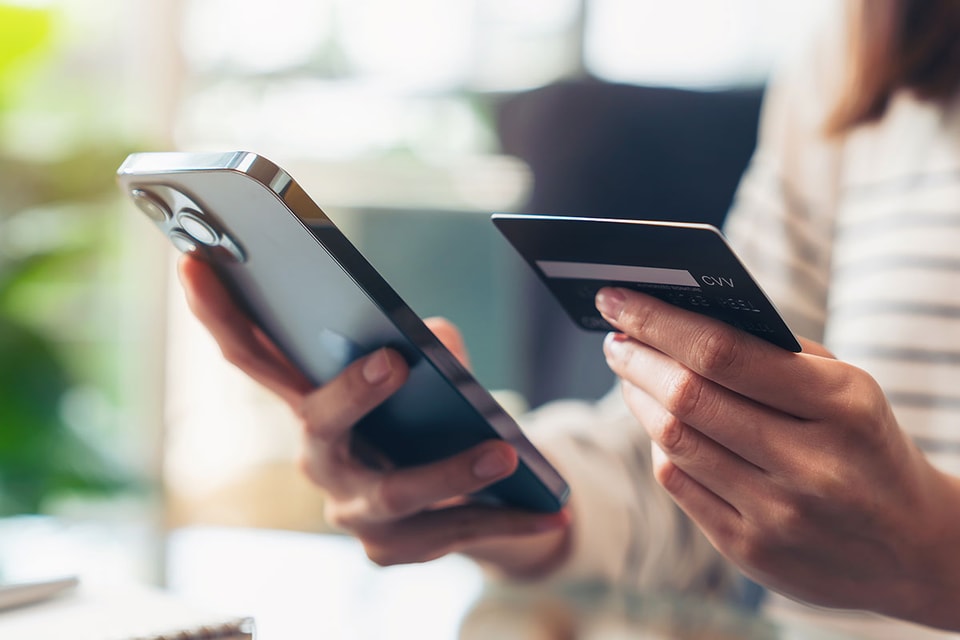 Dame holde kredittkort og mobil i hånden