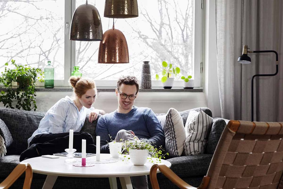 Par sitter sammen i koselig stue - illustrasjon for samboerkontrakt