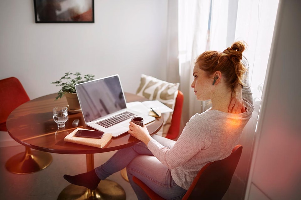 Dame sitter med laptop ved spisebordet, til illustrasjon for dokumentavgift