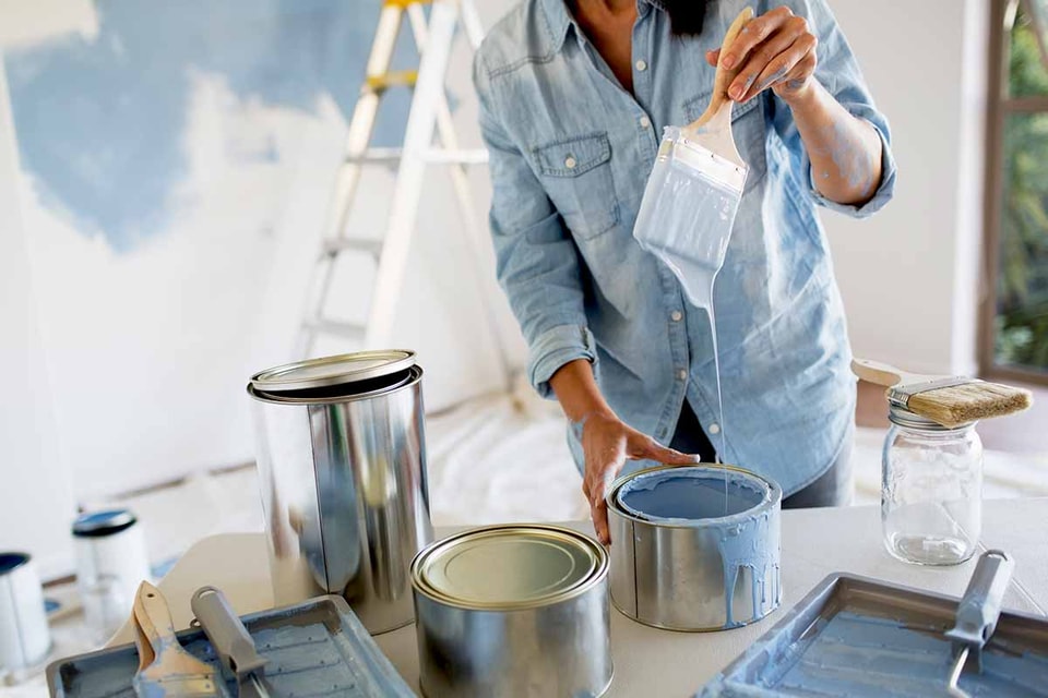 Dame med malingsspann og pensel, illustrasjon til pusse opp før salg av bolig