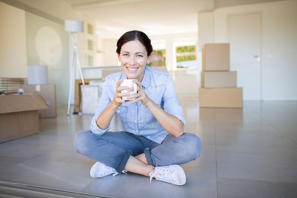 Dme sitteer på gulvet i ny leilighet, illustrasjon til spare til egenkapital