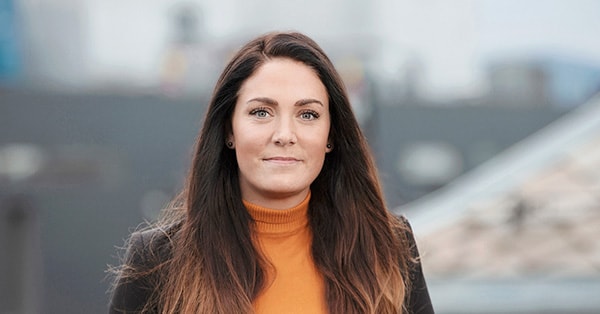 Kunderådgiver Marit smiler mot kamera, til illustrasjon for salg av bolig