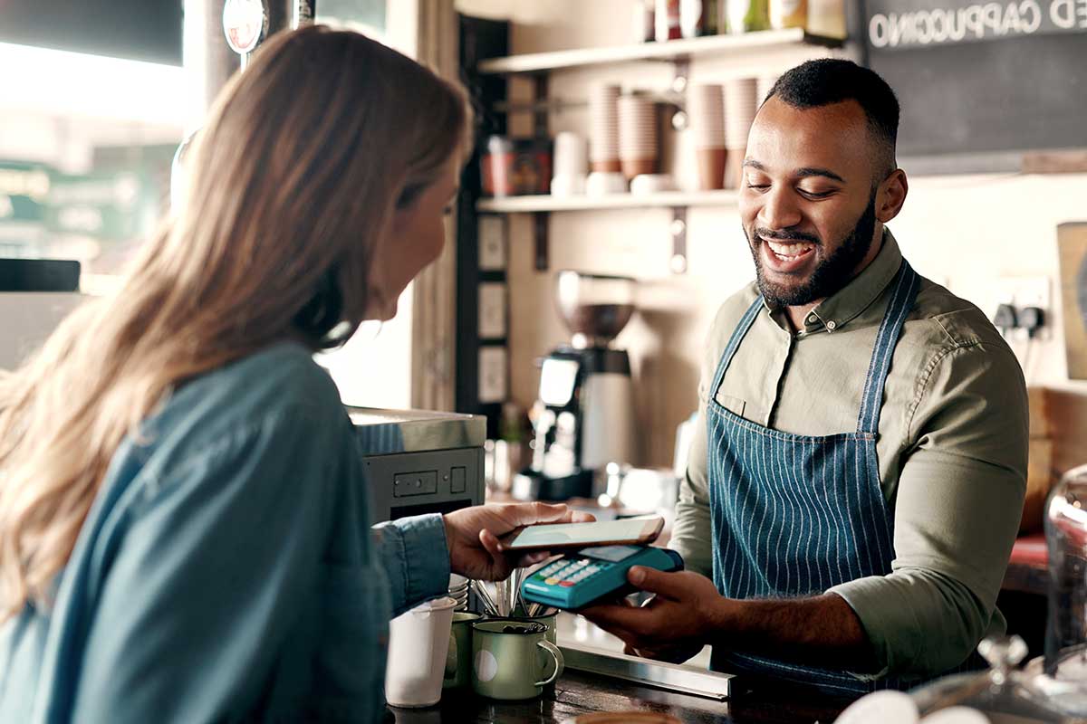 Kvinne betaler en barista for kaffe med Samsung Pay