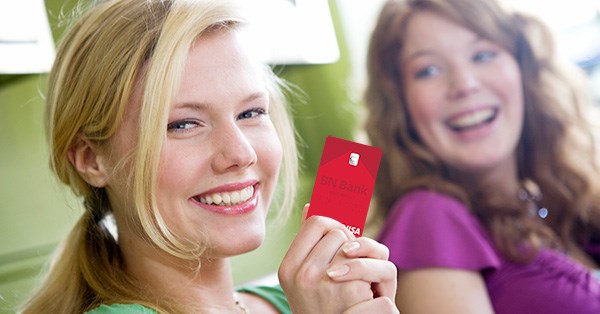 To ungdommer smiler mens de holder et bankkort fra BN Bank