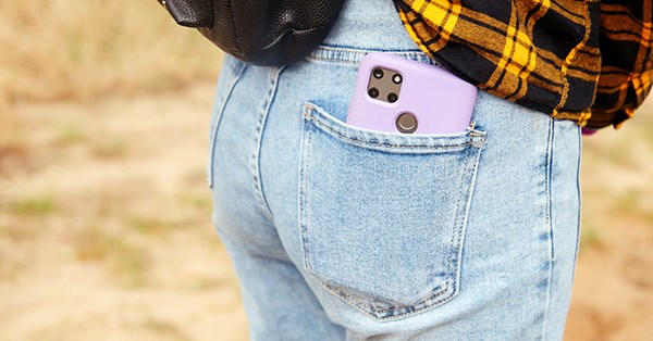 Jente har mobiltelefonen i baklomma på buksen, til illustrasjon for endelig myndig