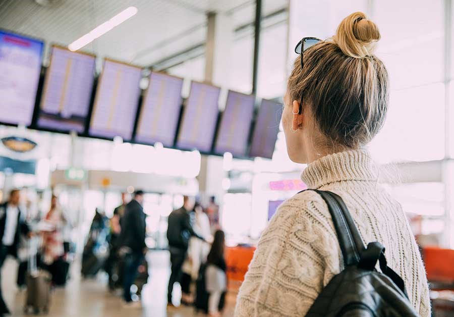Ung kvinne ser på flyavganger timeplan